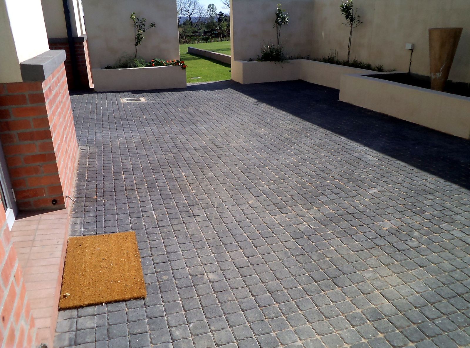 Luxury estate entrance — large-format charcoal courtyard paving